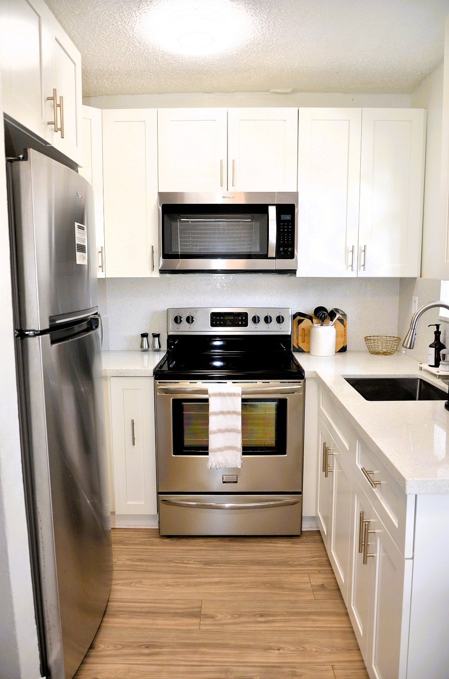 Fully equipped kitchen with stainless steel appliances, oven, and microwave, perfect for home-cooked meals or reheating takeout.