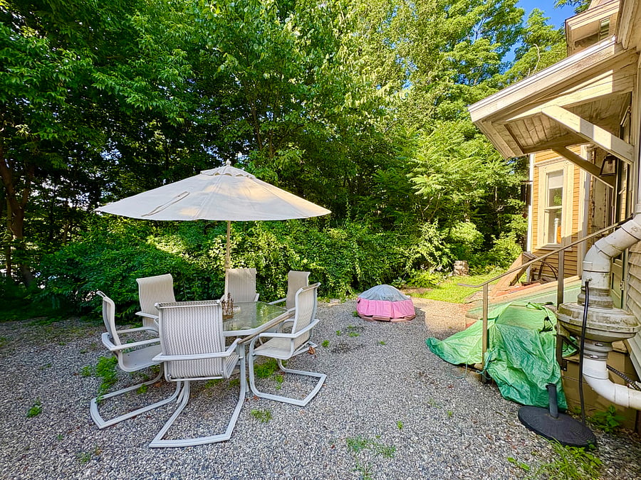 backyard with lovely sitting space and fire pit (under the pink cover)