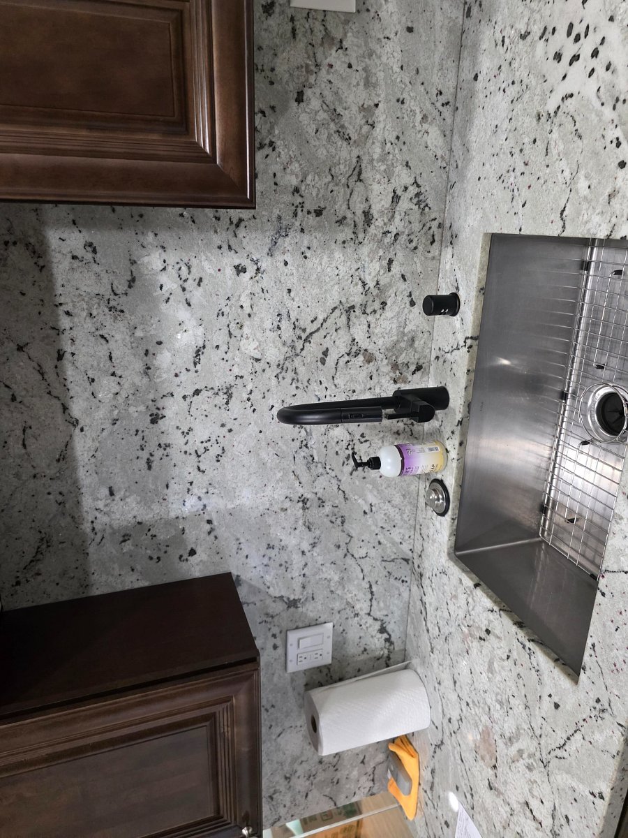 The elegant granite and deep stainless steel sink with the matte black faucet sets it stand part from most condos 