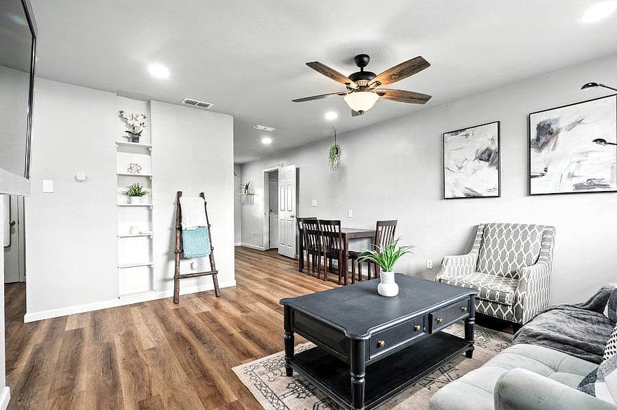 Living and dining areas from entry angle featuring a blanket ladder for comfort and smart Nest thermostat