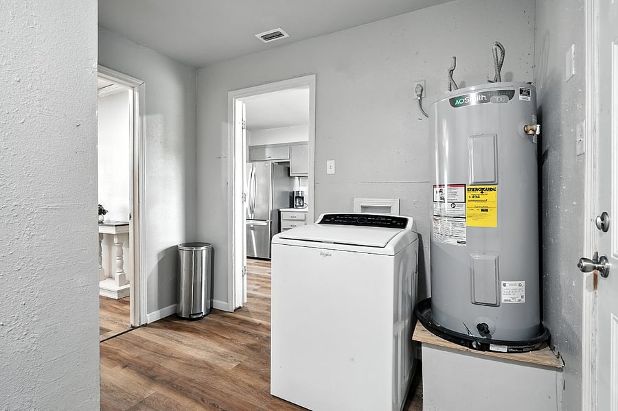 Laundry area featuring washer and stainless steel trash can