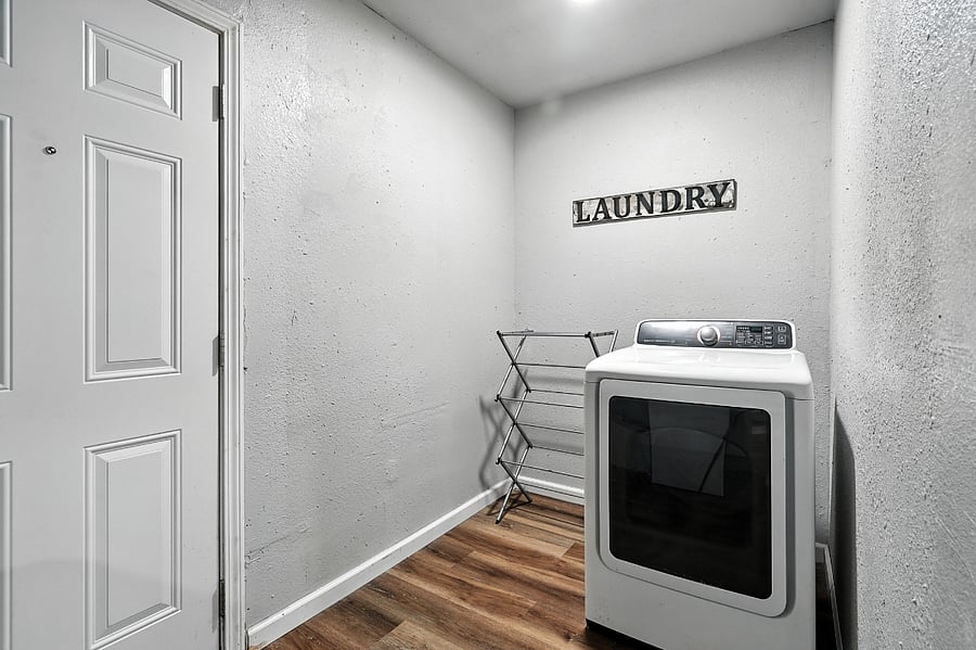 Laundry area featuring dryer and drying rack