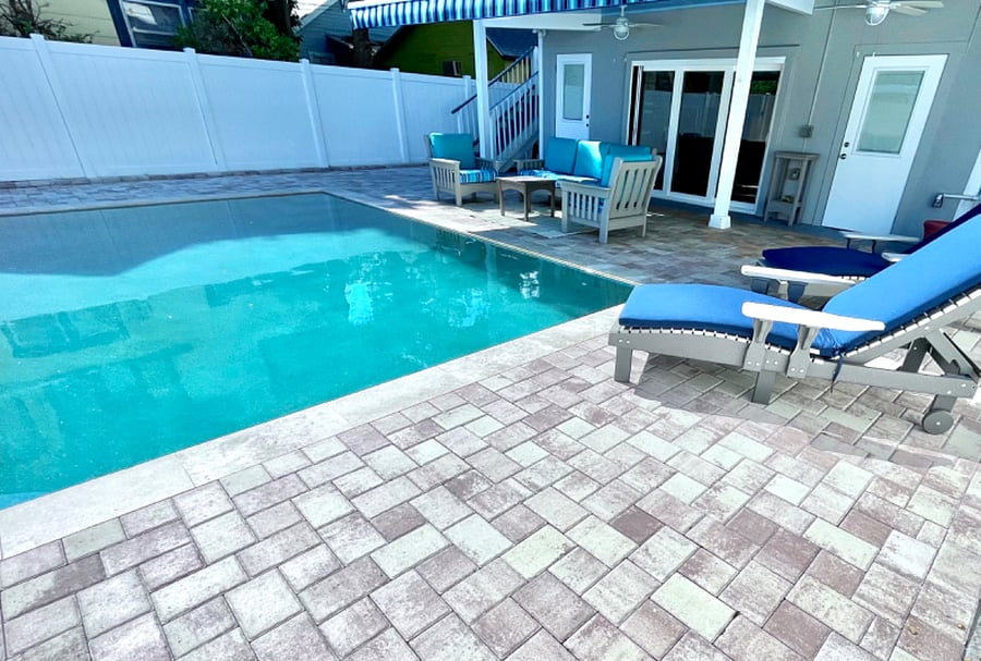 Lounge chairs with thick cushions for relaxing by the pool.