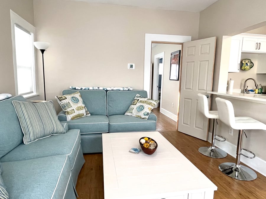 Living area includes two small couches, coffee table and breakfast bar with seating for two.