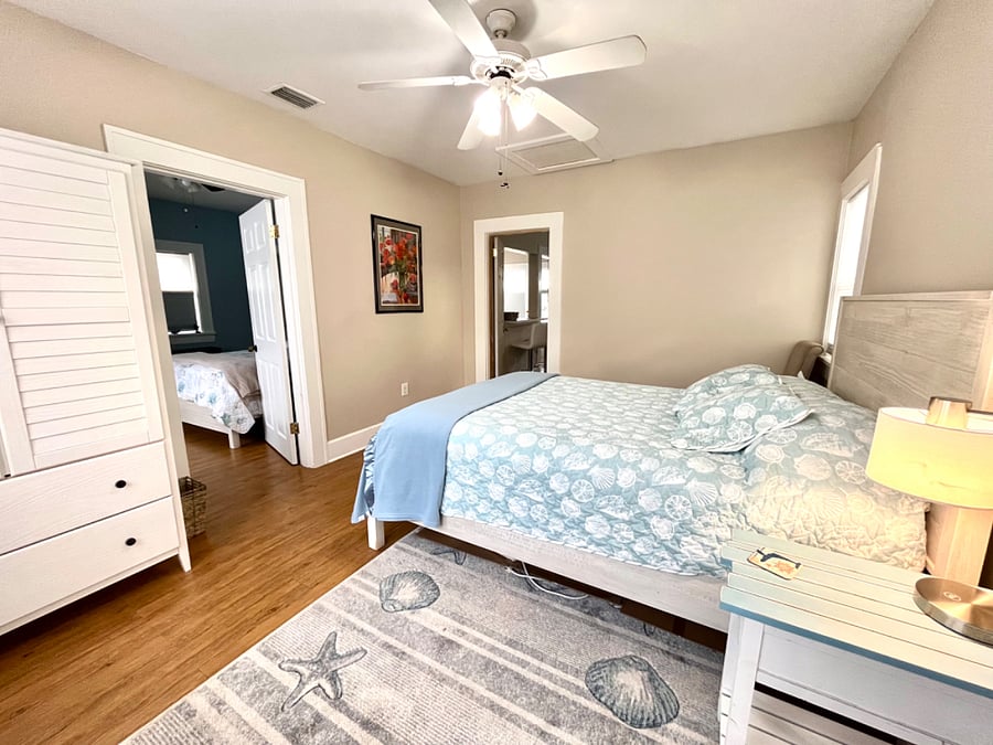 View of bedroom 1, showing armoire and table lamp.