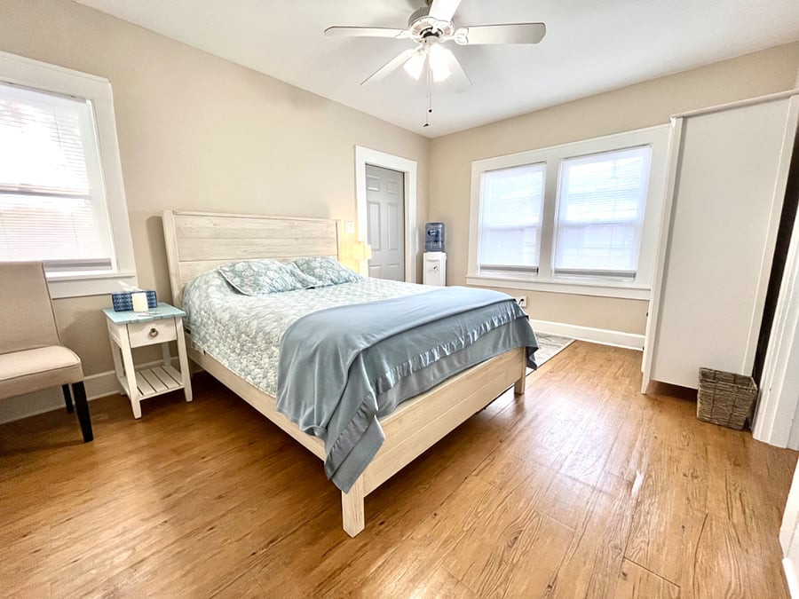 Bedroom 1 has queen bed, chair, armoire with hangers & shelving, night stands, door to small porch.