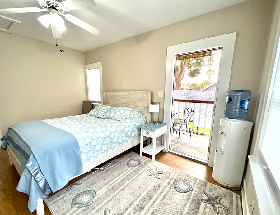 Bedroom 1 also has ceiling fan light, area rug and Water bubbler by door leading to porch.