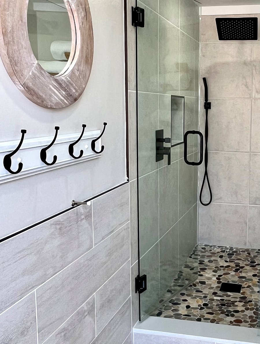 Bathroom 2 shower has glass enclosure, rain shower head, and hand-held sprayer.