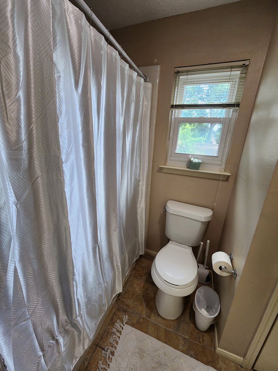 Toilet and bath in secondary guest room are separated with a door from the sink area