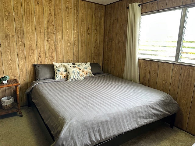 Quiet primary bedroom with king bed and blackout shades for restful sleep.