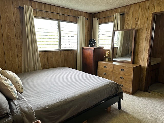 Primary bedroom with dresser, ample storage, and a convenient attached half bath.