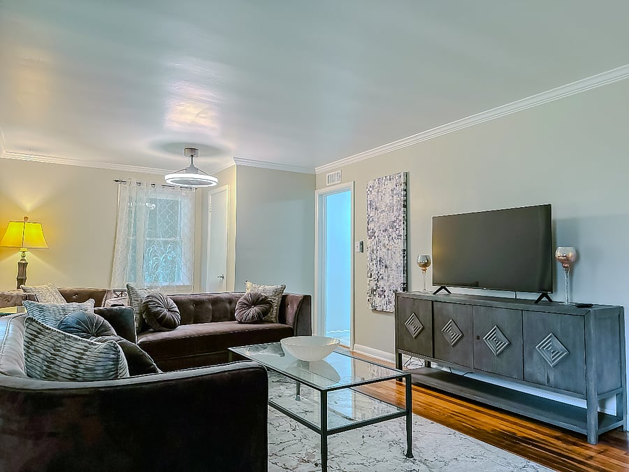Living room space with entrace to kitchen and first full bathroom with shower