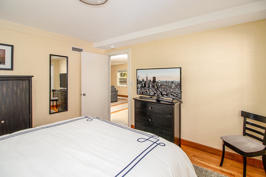 Bedroom has queen bed, night stand, armoire, dresser and TV