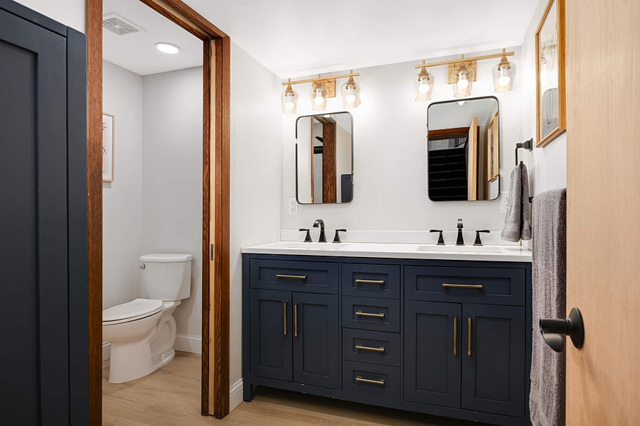 Lower Level fully renovated bathroom with double sink, separate walk in shower and toilet area