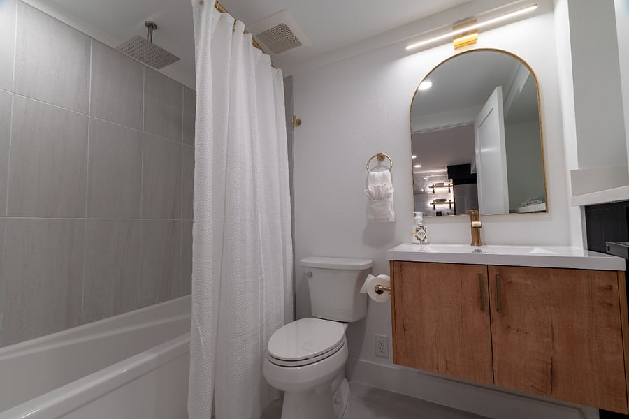 Relaxing tub with a soothing rain shower and hand held shower head for a spa-like experience.