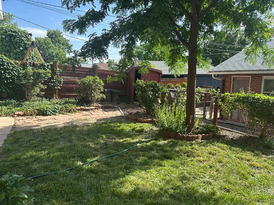 Reverse of back yard by apartment entry door toward south showing alley house