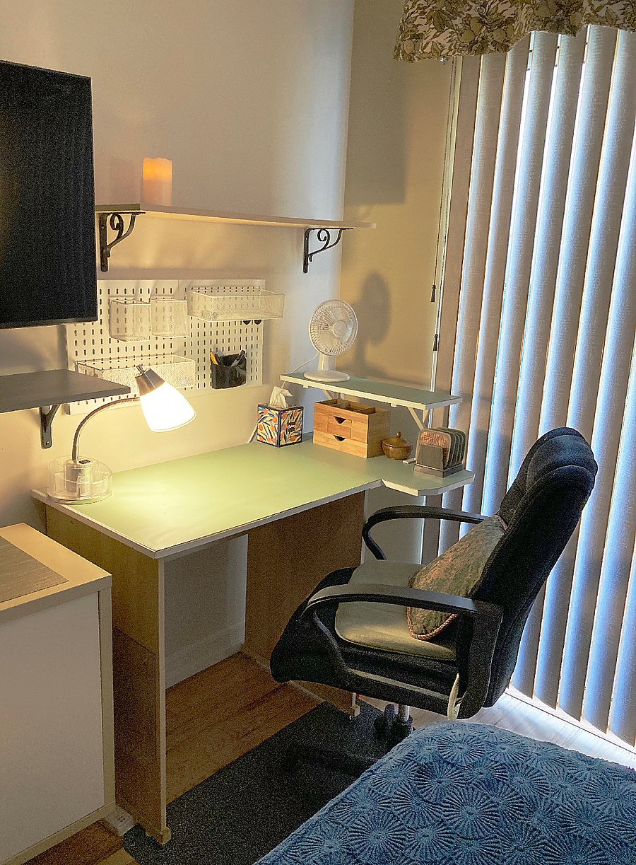 Desk & chair corner area, metal wall pegboard with organizers, small fan, surge protector w/ USB charger ports on floor. 