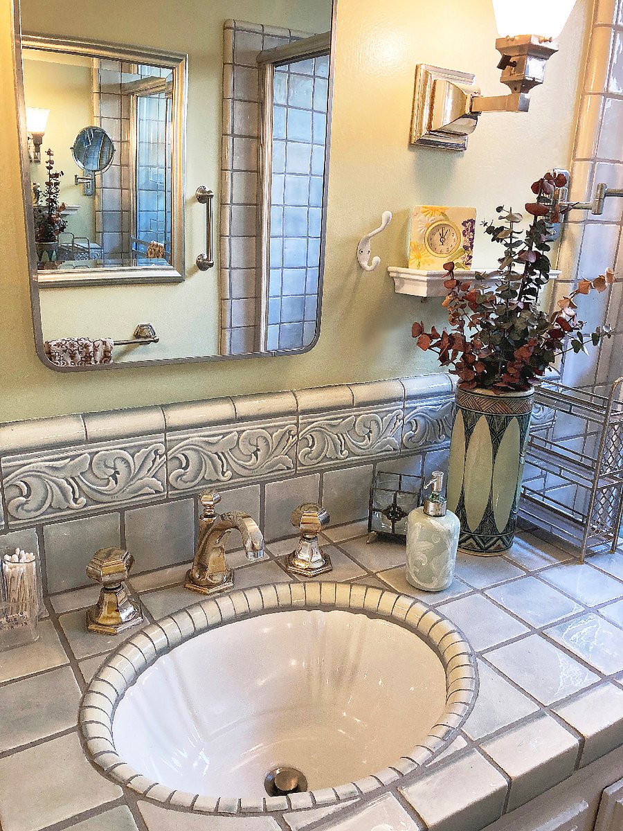 Sink area w/ polished nickel faucet, medicine cabinet & clock shelf.