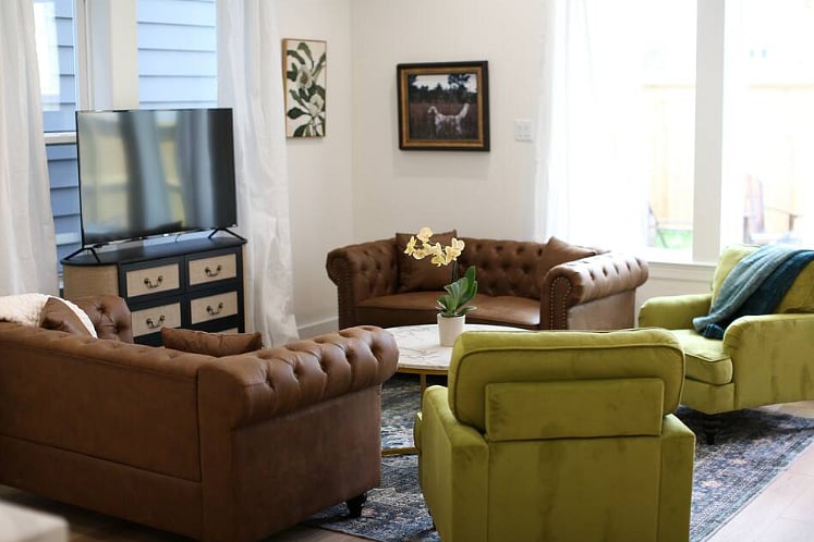 Spacious and comfortable living room with board games and a Roku TV. Opens out into a grassy back yard with a privacy fence, grill, table & chairs, corn hole, and life size jenga! 