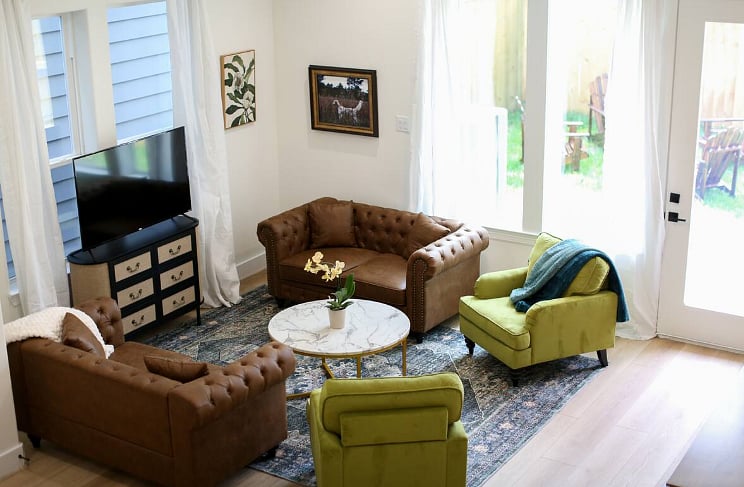 Spacious and comfortable living room with board games and a Roku TV. Opens out into a grassy back yard with a privacy fence, grill, table & chairs, corn hole, and life size jenga! 