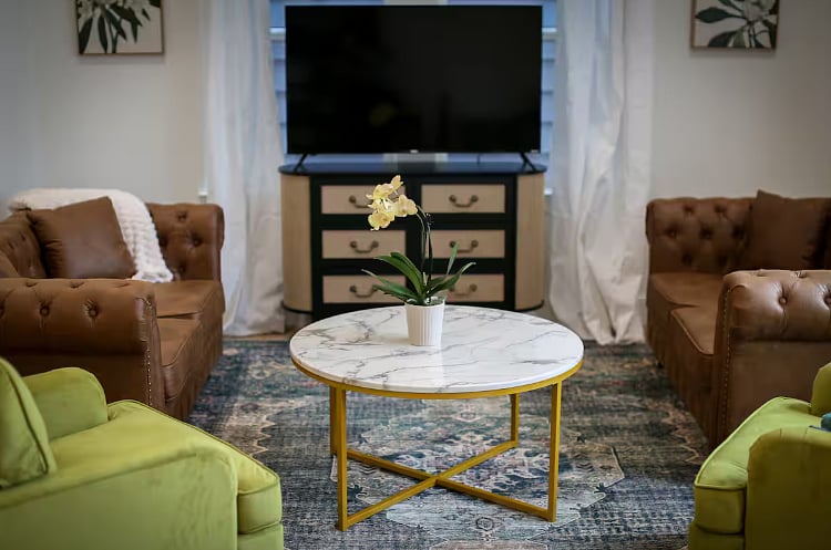 Spacious and comfortable living room with board games and a Roku TV. Opens out into a grassy back yard with a privacy fence, grill, table & chairs, corn hole, and life size jenga! 