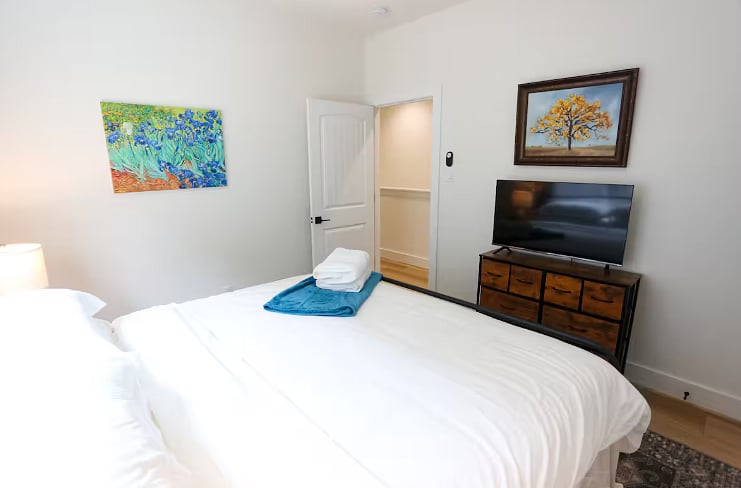 Bedroom Two shares a spacious bathroom with Bedroom Three. All four bedrooms boast a king size bed with 100% cotton sheets, a Roku TV, blackout curtains, and a walk-in closet. 