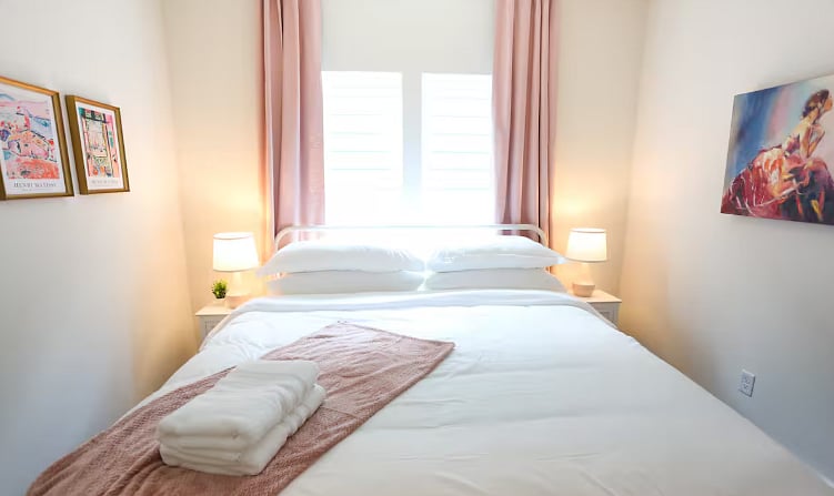 Bedroom Three shares a spacious bathroom with Bedroom Two. All four bedrooms boast a king size bed with 100% cotton sheets, a Roku TV, blackout curtains, and a walk-in closet. 