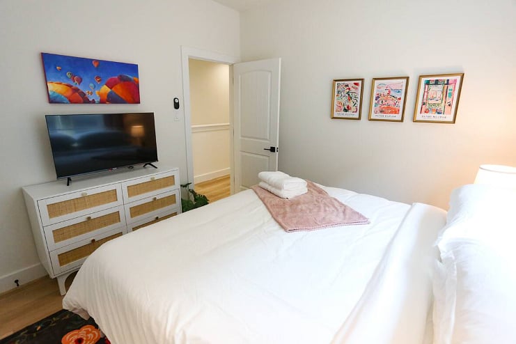 Bedroom Three shares a spacious bathroom with Bedroom Two. All four bedrooms boast a king size bed with 100% cotton sheets, a Roku TV, blackout curtains, and a walk-in closet. 