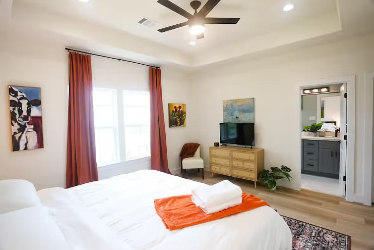 Bedroom Four includes a spacious en suite bathroom. All four bedrooms boast a king size bed with 100% cotton sheets, a Roku TV, blackout curtains, and a walk-in closet. 