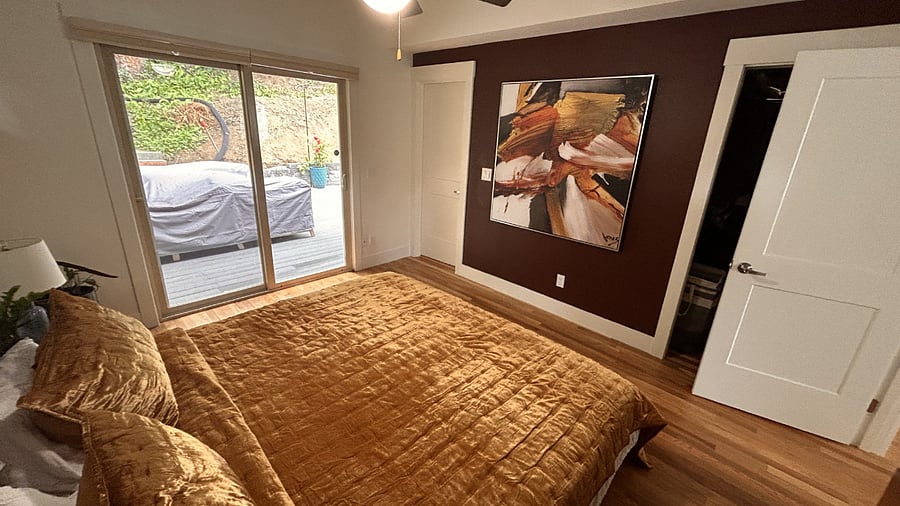 Primary bedroom with a view to the private backyard forest