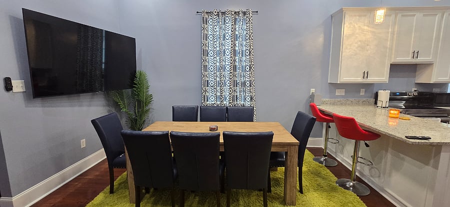 Large dining room with 8 seat conference table and LG Smart television. 