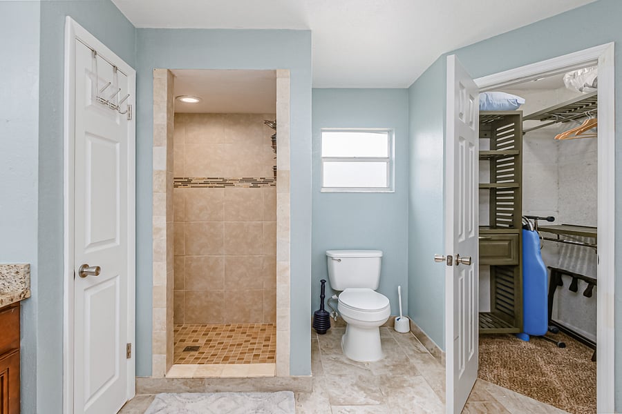 Primary Bathroom Shower, Toilet, and 1 of 2 Mirroring Closets