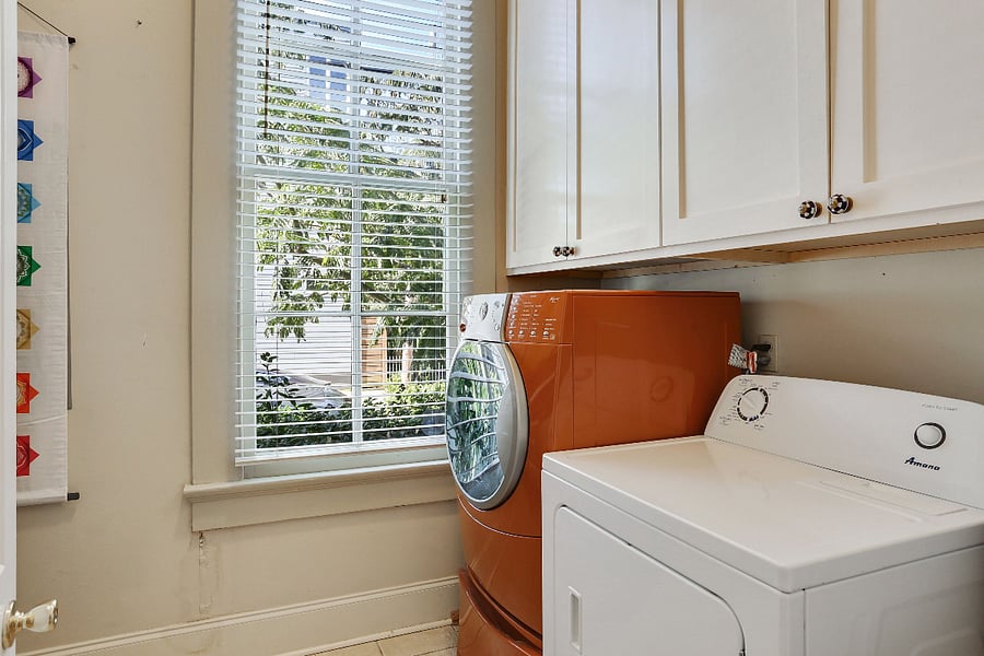 full laundry room with sink and cabinets.