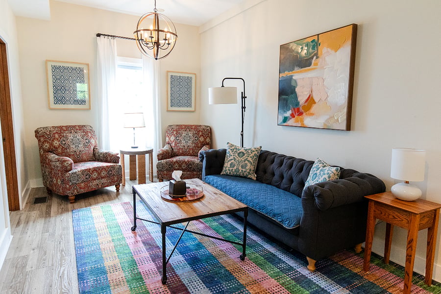 The living room has a couch and two armchairs.