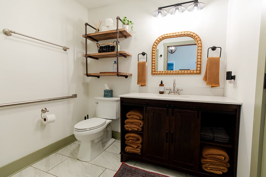 The bathroom has a single sink vanity and walk-in shower. (Bath linens are provided for STR guests).