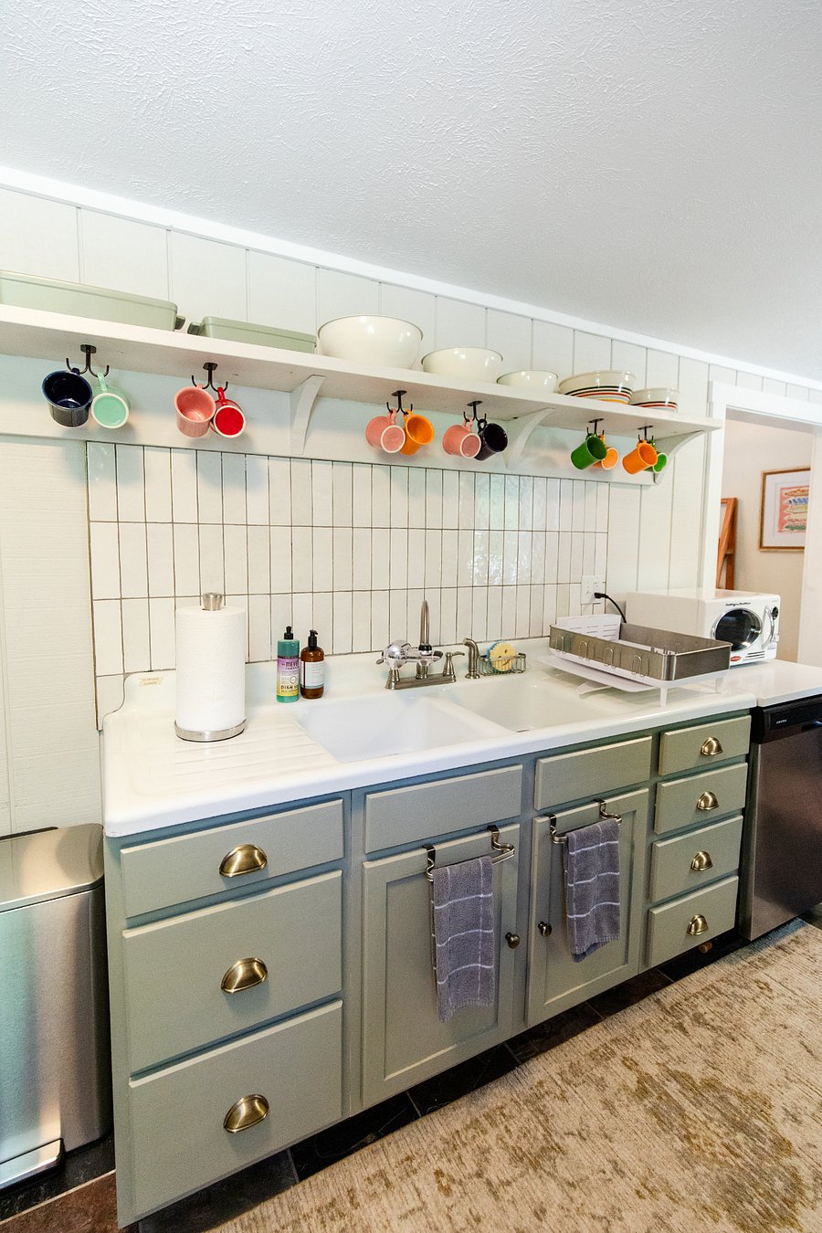 A vintage-style sink with a modern tile backsplash gives the kitchen loads of charm.