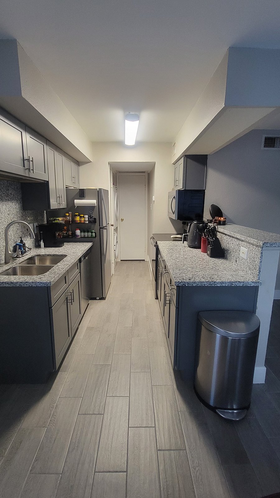 Newly remodeled kitchen equipped with all new stainless steel appliances (sink, dishwasher, refrigerator, stove, and microwave range), granite countertops and backsplash, and new shaker cabinetry.