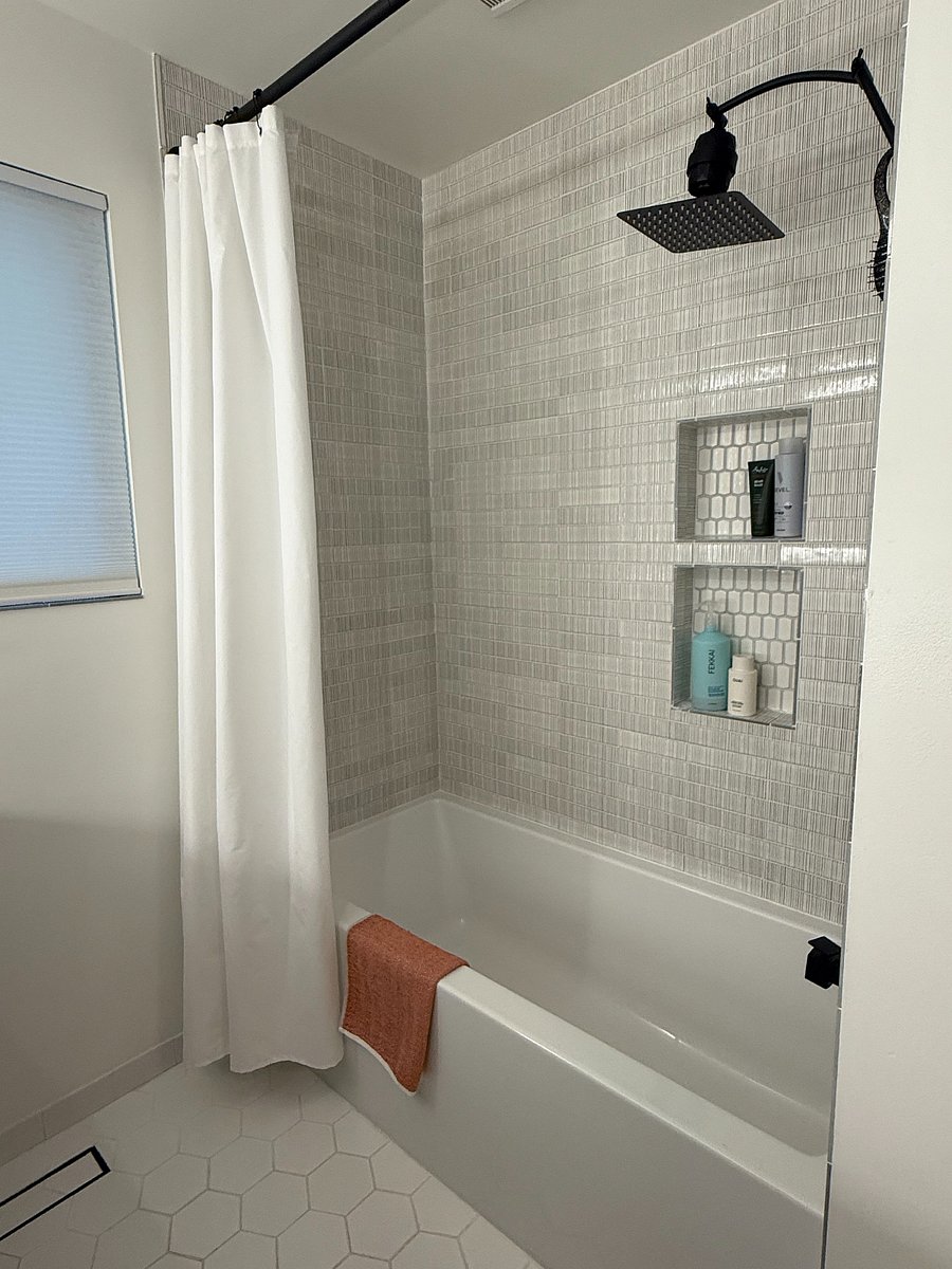 remodeled bathroom with heated floor, heated towel rack, and deep soaking tub