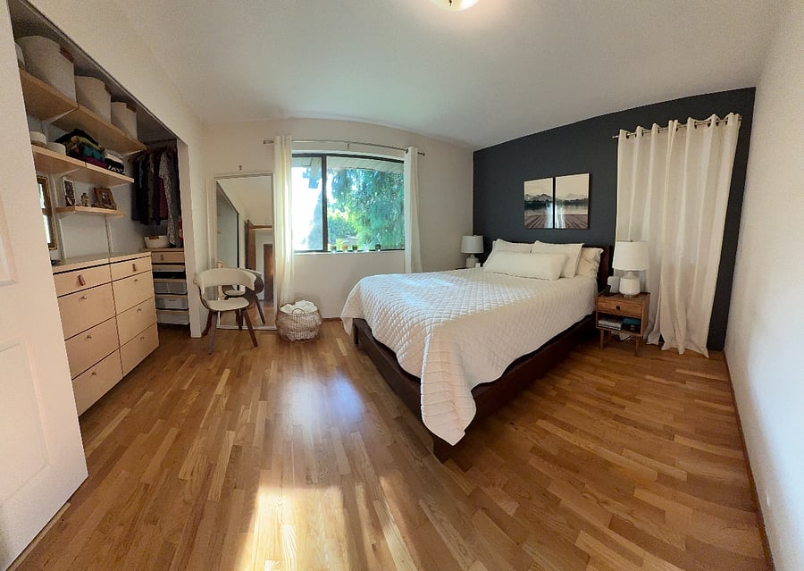 bedroom with queen bed, two closets with Elfa system, beautiful view of trees