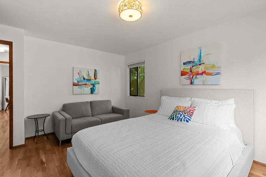 largest bedroom with queen bed, couch and large closet with Elfa system