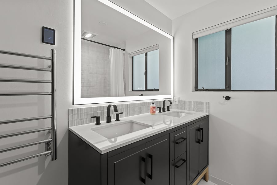 remodeled bathroom with heated floor, heated towel rack, and deep soaking tub