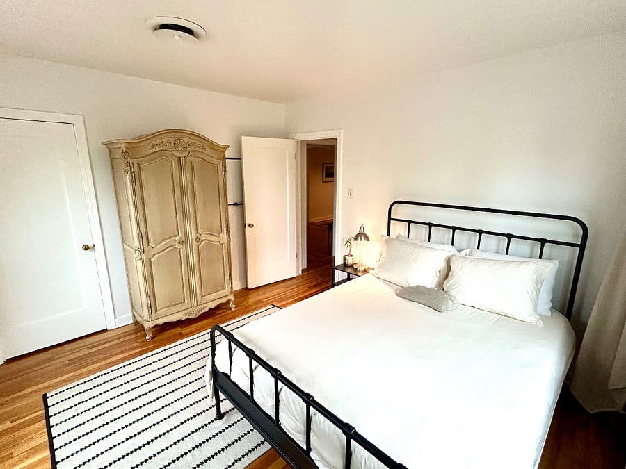Spacious second bedroom with walk-in closet, new queen bed with 2 organic mattress topper and plush 100% cotton bedding, armoire, soft wool rug, electric standing desk and large screen TV.