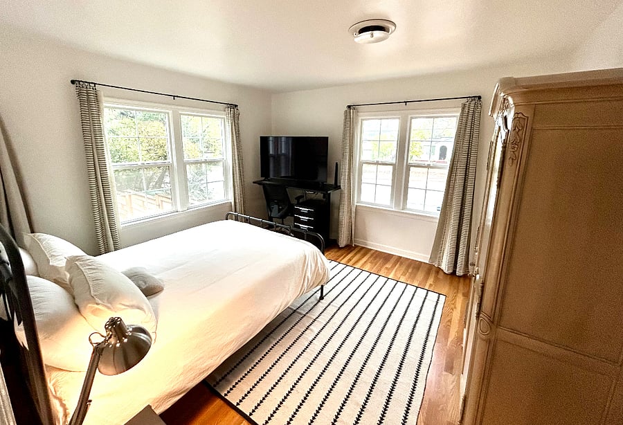 Spacious second bedroom with walk-in closet, new queen bed with 2 organic mattress topper and plush 100% cotton bedding, armoire, soft wool rug, electric standing desk and large screen TV.