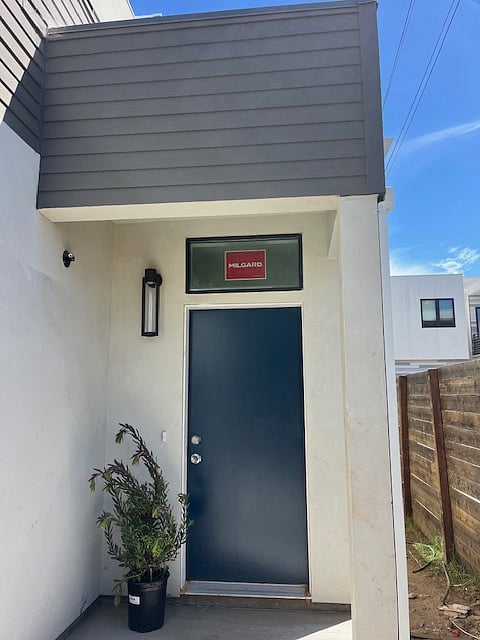 Private gated front porch, entry into the unit has a window above the door for natural light