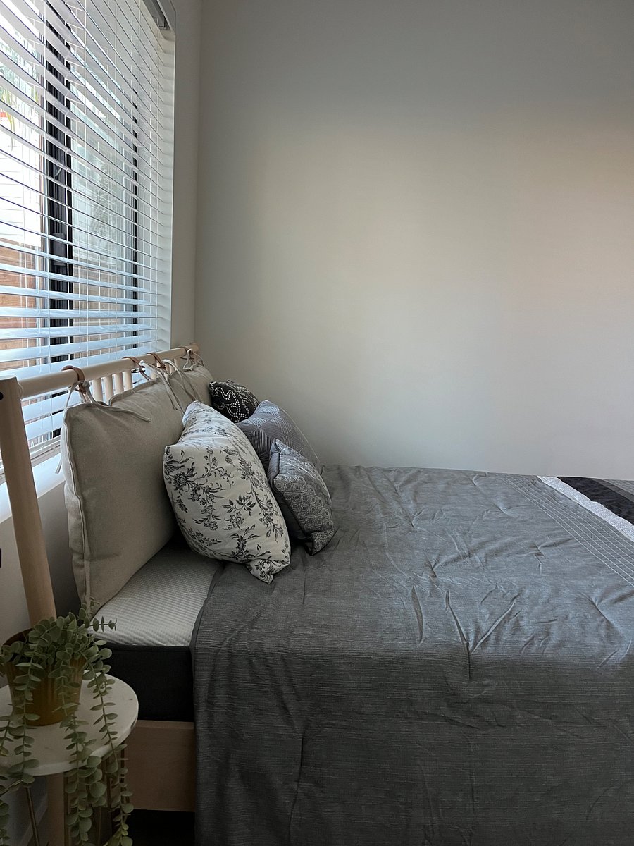 Bedroom 1: Queen bed, small night stand and small extendable desk, walk in closet. Natural light through large window.