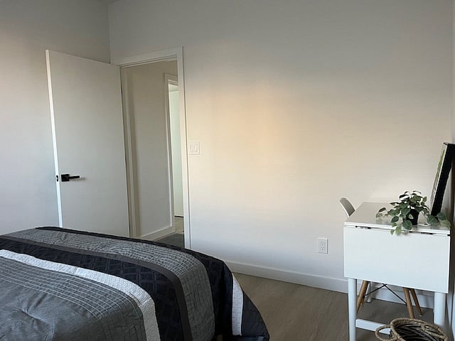 Bedroom 1: view of queen bed and small desk
