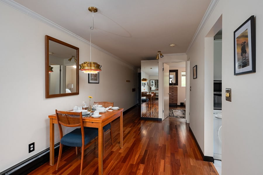 Kitchenette hallway with dining table and chairs. Built in full sized mirror leading to hallway and front door.
