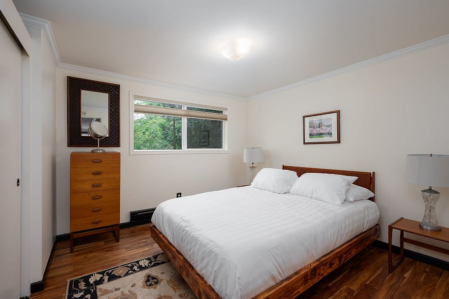 Bedroom with Queen sized bed. Dresser and side tables. Queen mattress with new linens.