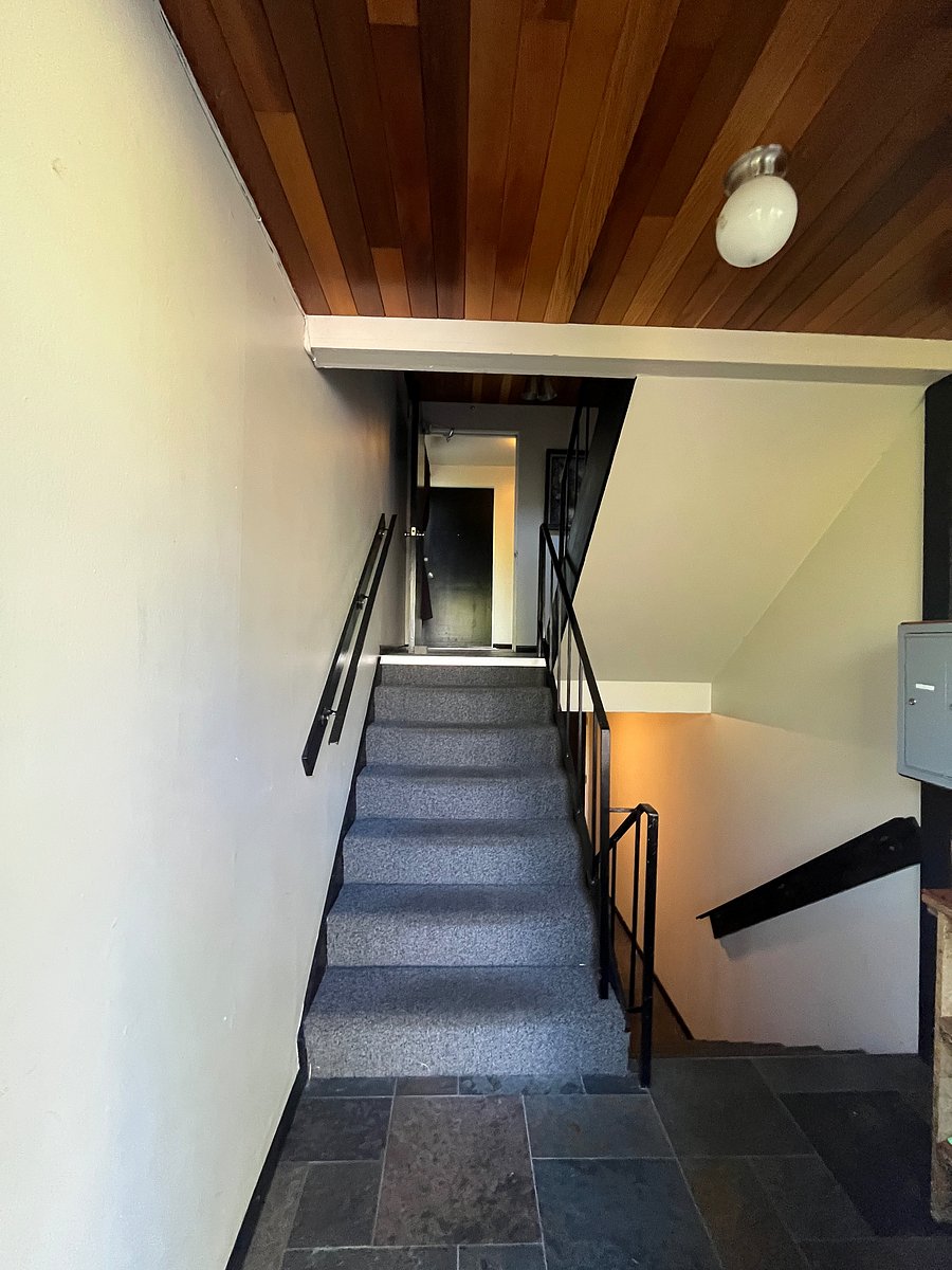 Stairs leading to the 2nd floor units inside the front door by the mailbox area.