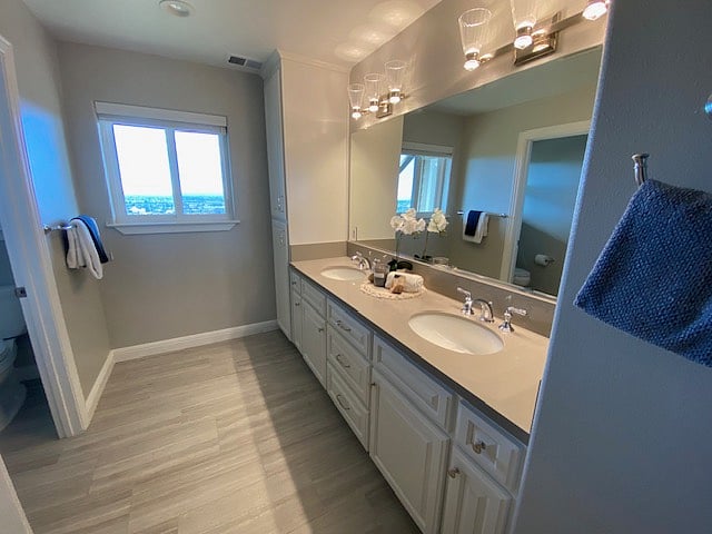 Full bath with dual vanity and separate water-closet.
